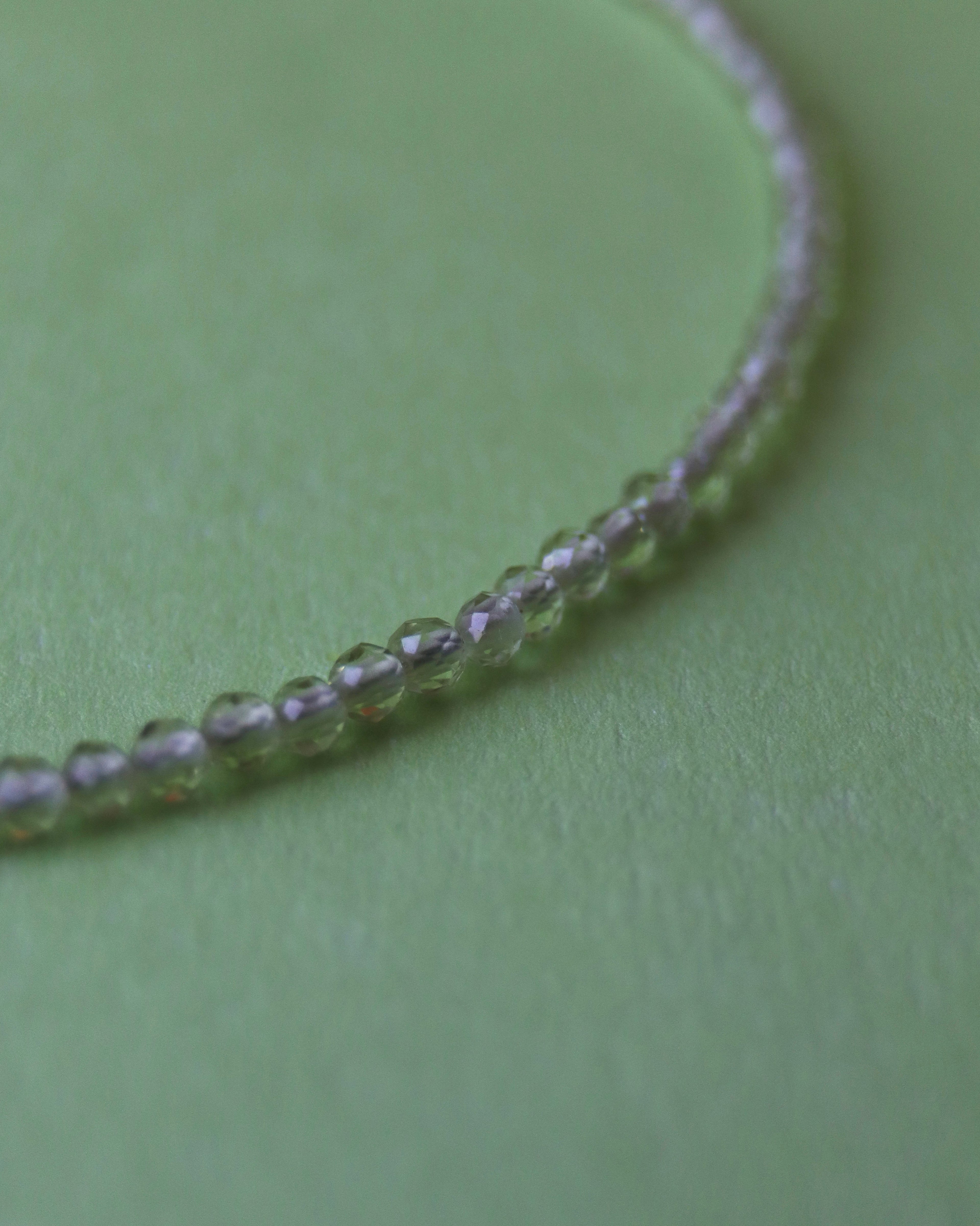 Close-up of a beaded necklace on a green surface
